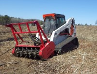 A red and white forestry mower in a recently mowed field.